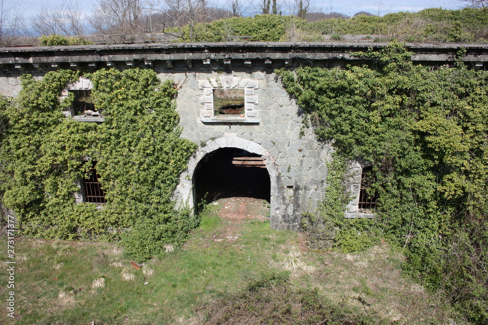 scary access portal, arched to enter the Fort Bastion of Fosdinovo, a fortress taken by nature and wild vegetation