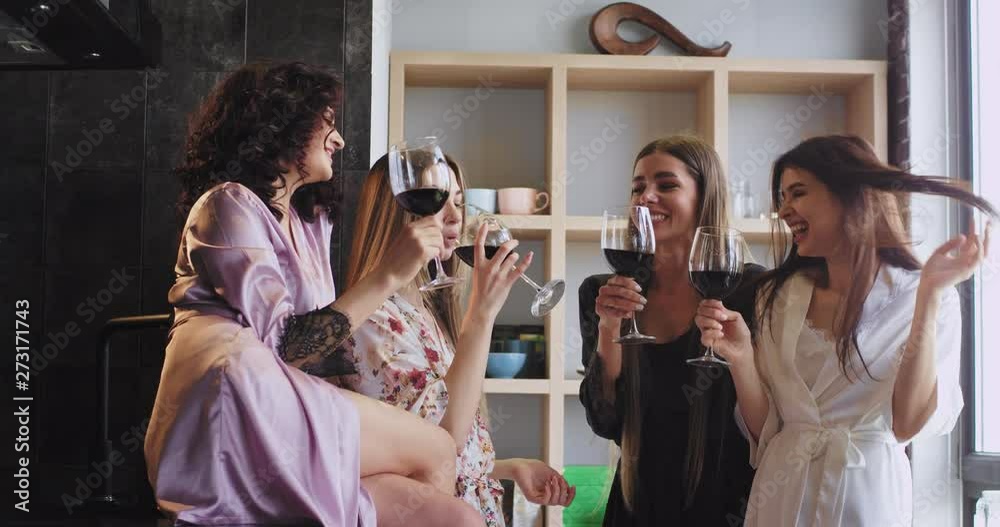 group of ladies very charismatic and smiling pretty cheers with wine glasses feeling good in pajamas they enjoying the time together in a modern studio apartment group of ladies very charismatic and smiling pretty cheers with wine glasses feeling good in pajamas they enjoying the time together in a modern studio apartment