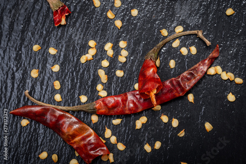Dried Mexican Red Chile De Arbol Pepper on black natural stone background. Capsicum annuum.