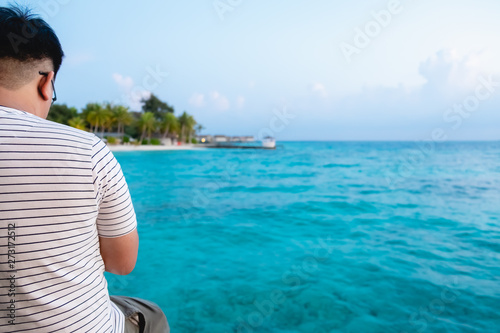 relaxed man looking over the blue ocean in Maldives