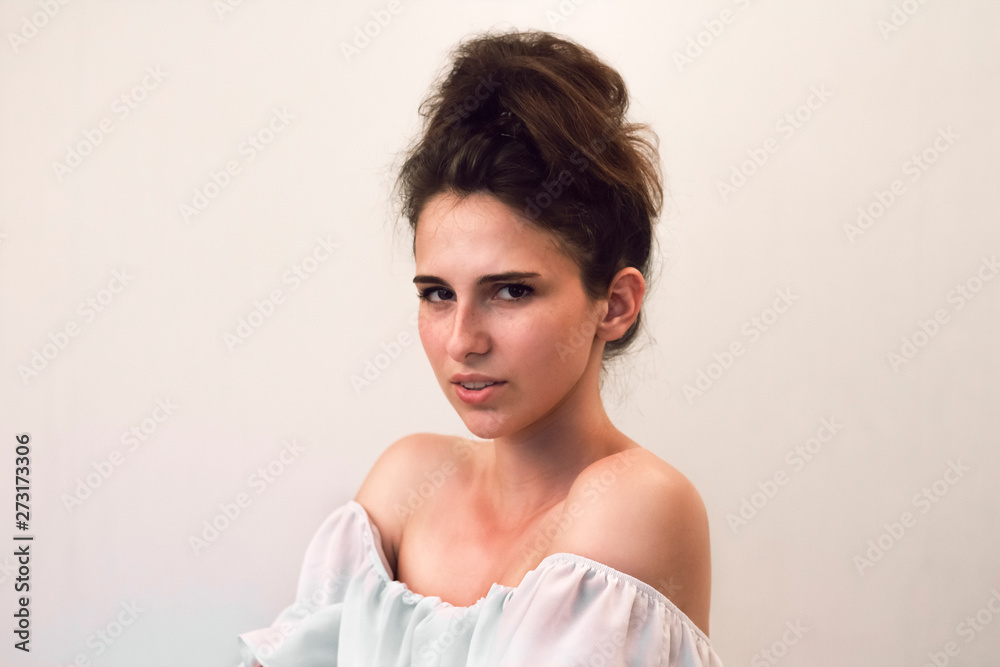 Close up photo portrait of young beautiful woman with freckles which looking at the camera with anger and sadness. Pretty natural face on gray background. Close up photo portrait of young beautiful woman with freckles which looking at the camera with anger and sadness. Pretty natural face on gray background.