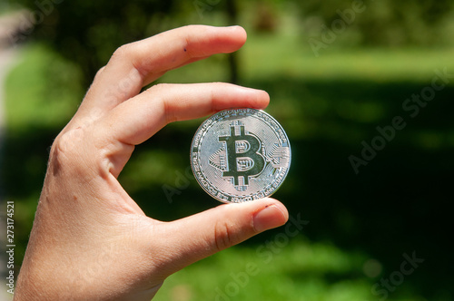 Bitcoin in hand of a casual businessman wondering