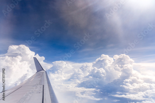 Flying into blue sky and sea of clouds and Wing of airplane with skyline  top view as look from window airplane, during flight space for  text message, frame or traveling idea concept © lukyeee_nuttawut