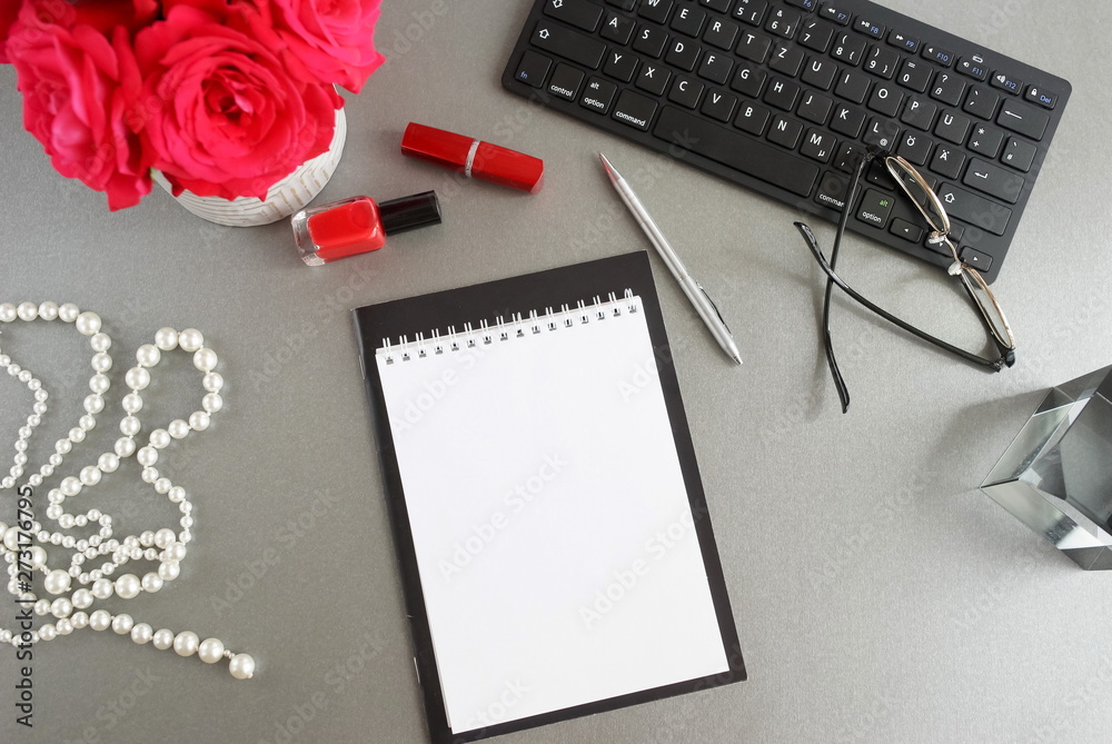 Flat lay women's office desk. Female workspace with laptop, bouquet flowers red roses, accessories, notebooks mock up, glasses on grey background. Top view feminine desk.Copy space. Flat lay women's office desk. Female workspace with laptop, bouquet flowers red roses, accessories, notebooks mock up, glasses on grey background. Top view feminine desk.Copy space.
