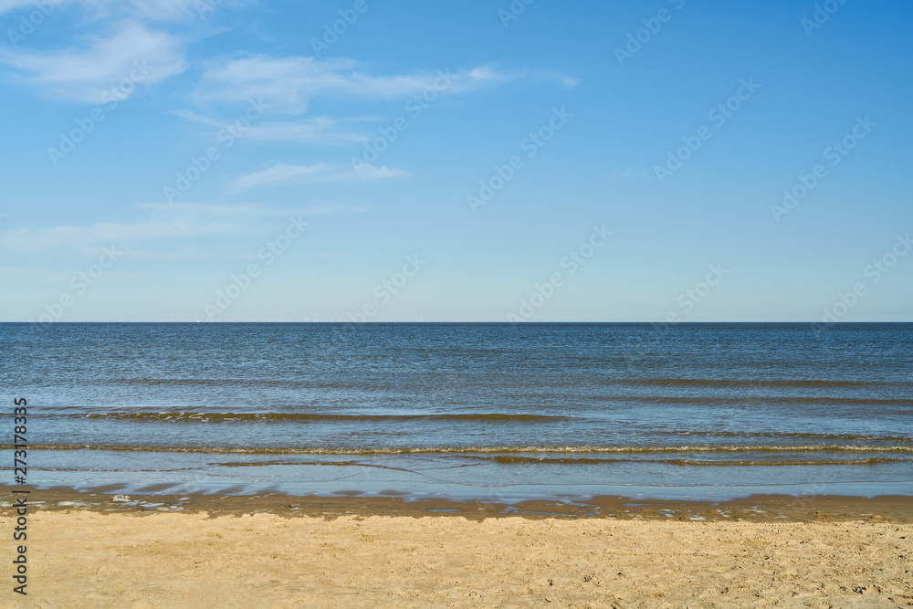 Waves in the sea in front of sky with clouds