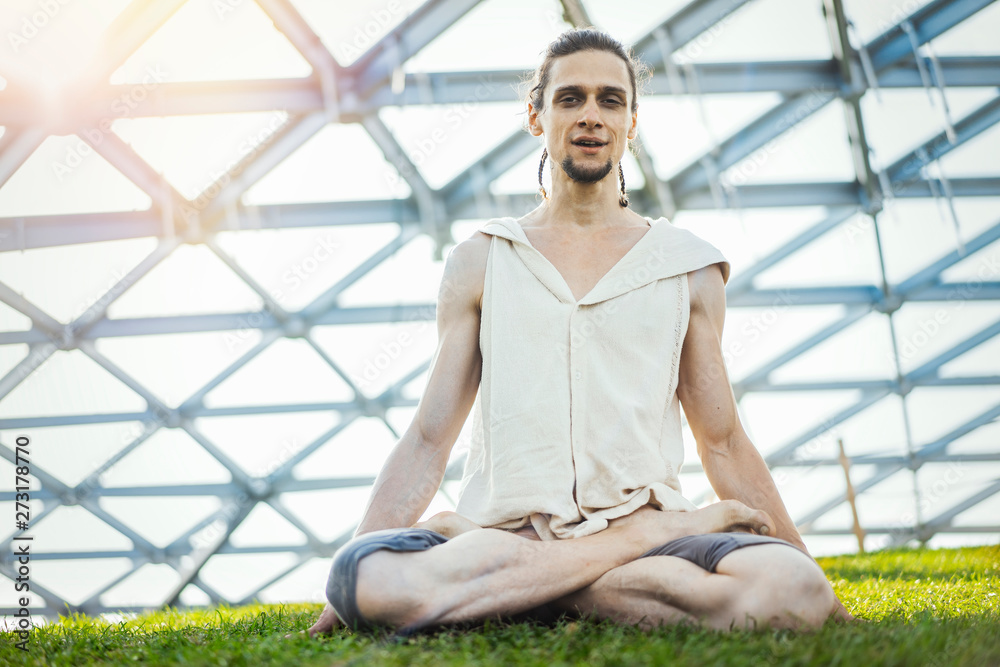 Close up of attractive athletic man practicing yoga and meditating outdoors. Close up of attractive athletic man practicing yoga and meditating outdoors.