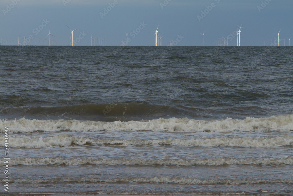 Large offshore wind farm on horizon from beach