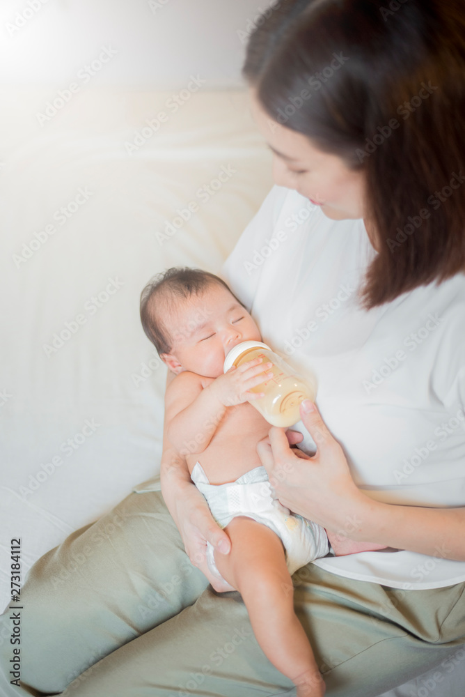 Newborn baby girl is drinking milk by her mother Newborn baby girl is drinking milk by her mother