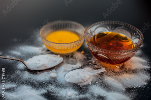 Baking soda face mask in a glass bowl on wooden surface along with baking soda powder and honey for Dark lips. Horizontal shot. photo
