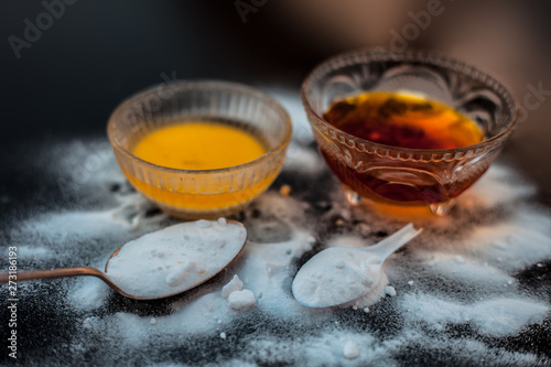 Baking soda face mask in a glass bowl on wooden surface along with baking soda powder and honey for Dark lips. Horizontal shot. photo