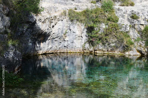 Lago de agua azul y cristalina entre monta  as de caliza.