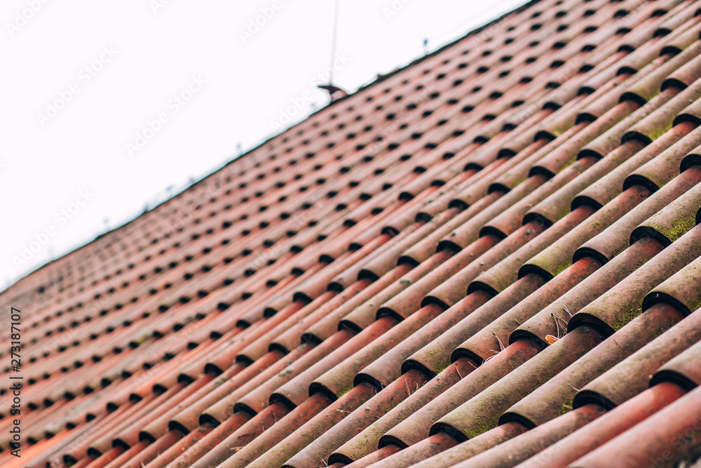 Naklejka premium Exterior of brick house with red roof tiles, Prague. Retro red tile roof of old house