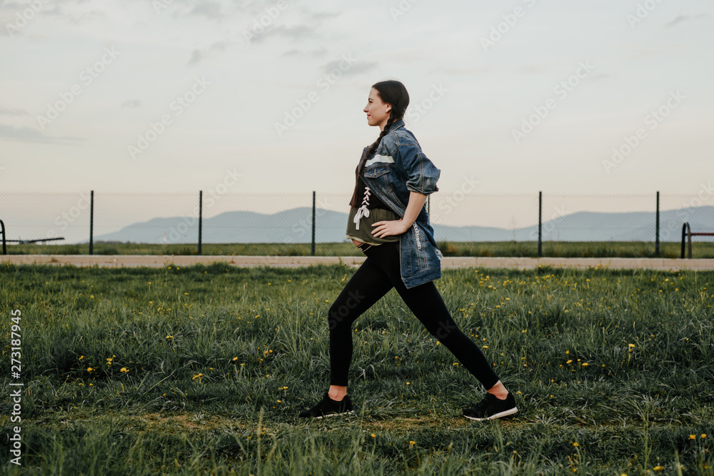 Pregnant woman is exercising outside. The concept of taking care of yourself during pregnancy. Training during pregnancy. An active mom expecting a baby. Pregnant woman is exercising outside. The concept of taking care of yourself during pregnancy. Training during pregnancy. An active mom expecting a baby.