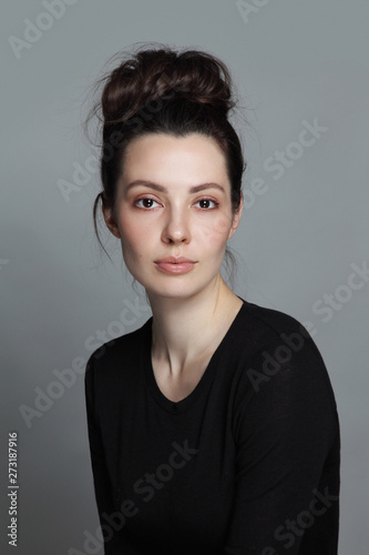 Portrait of young beautiful woman with clean makeup and fancy hair bun
