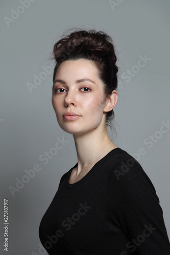 Portrait of young beautiful woman with clean makeup and fancy hair bun