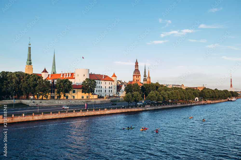 Panoramic view of the Old Town from the cable-stayed bridge to the Daugava embankment at sunset. Riga, Latvia. Riga Castle with the Riga Cathedral in front of. St. Peter's Church in the background.