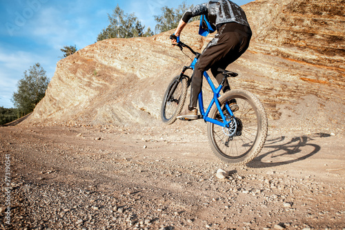 Professional well-equipped cyclist riding bicycle on the rocky mountains. Concept of a freeride and off road cycling