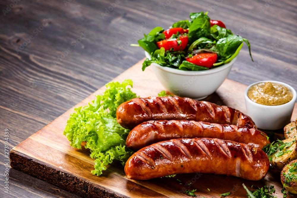 Grilled sausages and vegetables on cutting board Grilled sausages and vegetables on cutting board