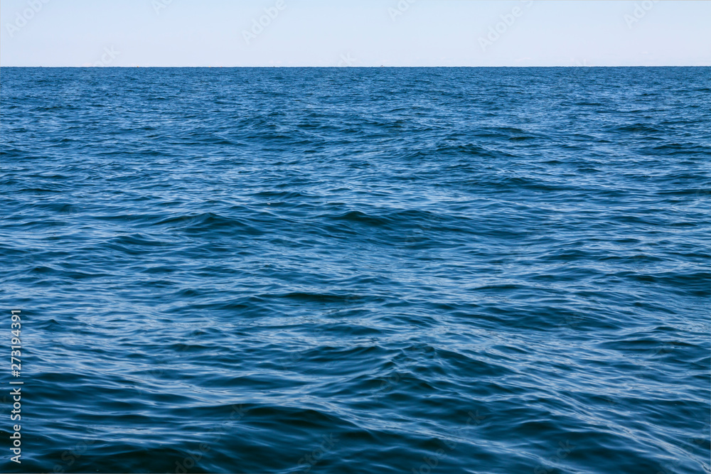 Background, small waves of the sea, and above them the blue sky. Background, small waves of the sea, and above them the blue sky.
