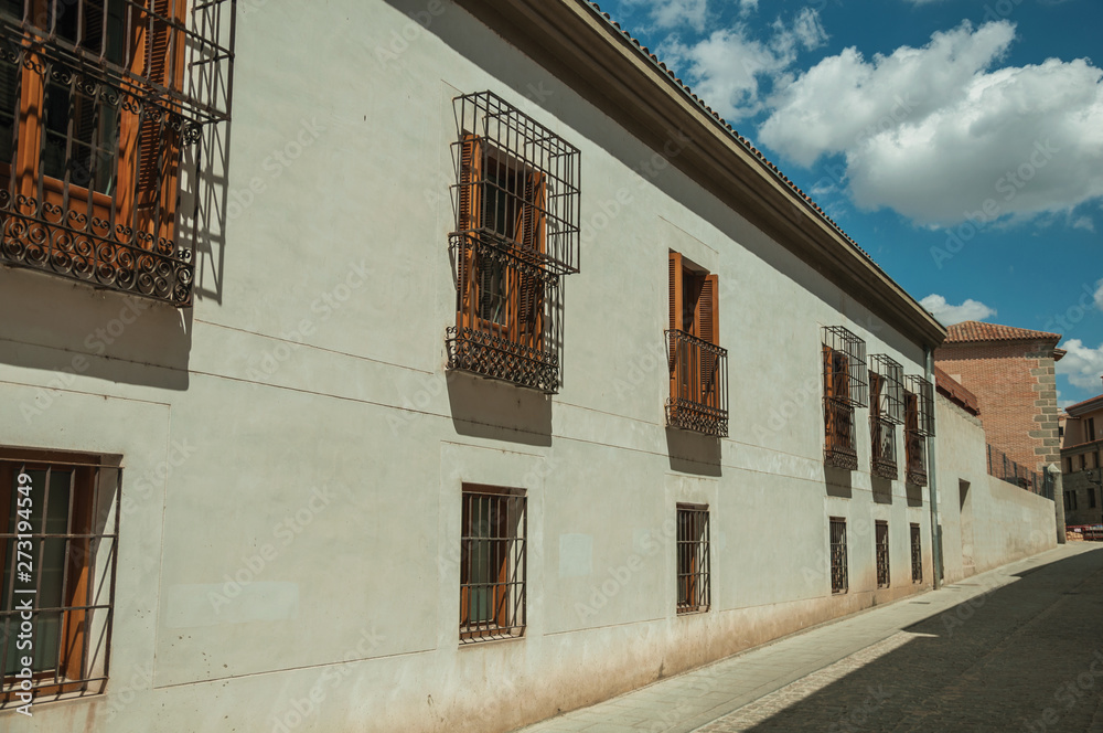Alley and old building with protective iron grids on windows at Avila