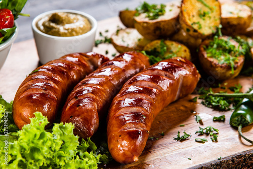 Grilled sausages and vegetables on cutting board photo