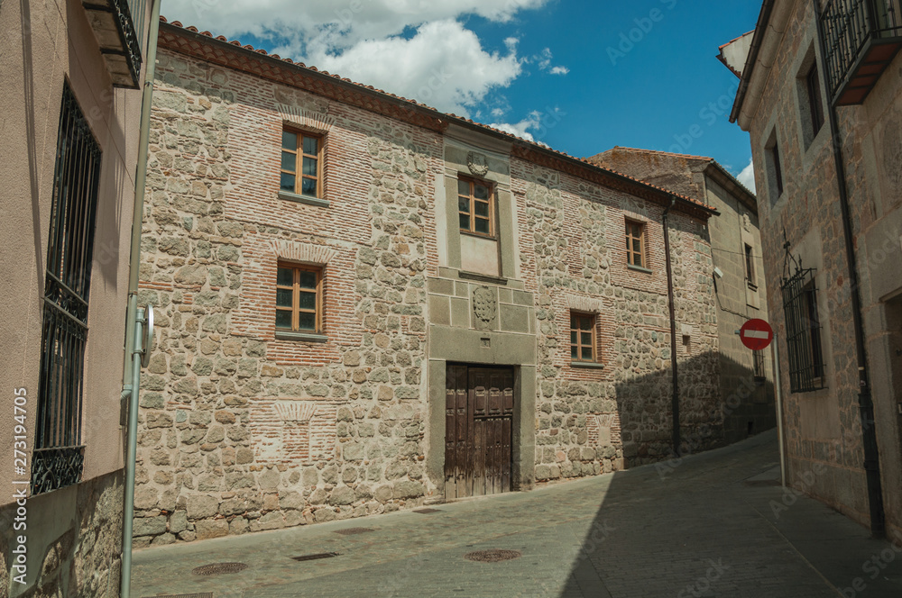 Deserted alley and old building with wooden door at Avila