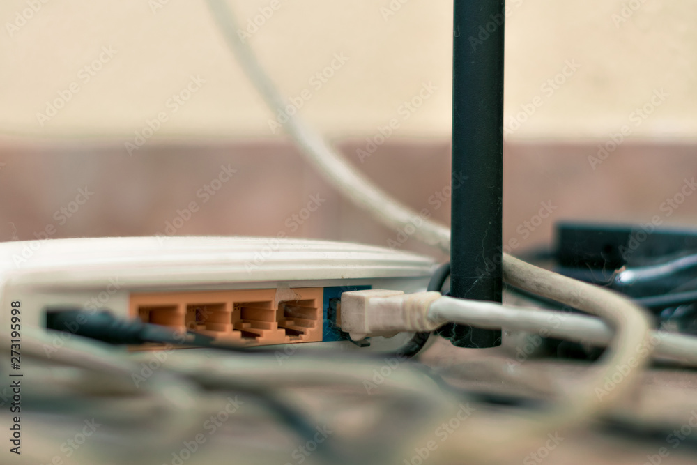Old router among the wires and the web. Rear side of the router with connectors for connecting the Ethernet cable
