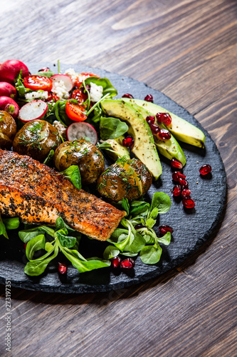 Grilled salmon, baked potatoes and vegetable salad