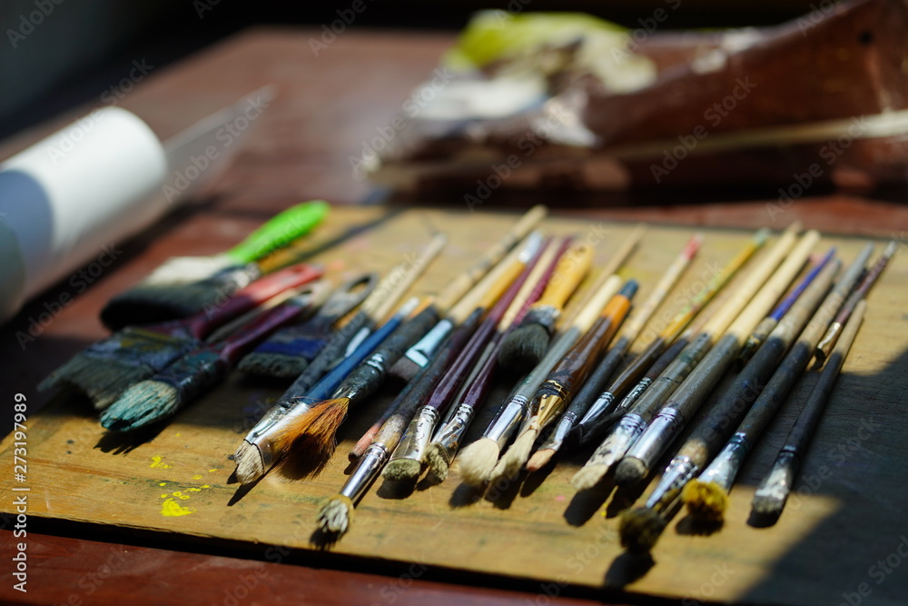 Artist brushes lie on a wooden board. The working environment of the artist for the background. Artist brushes lie on a wooden board. The working environment of the artist for the background.