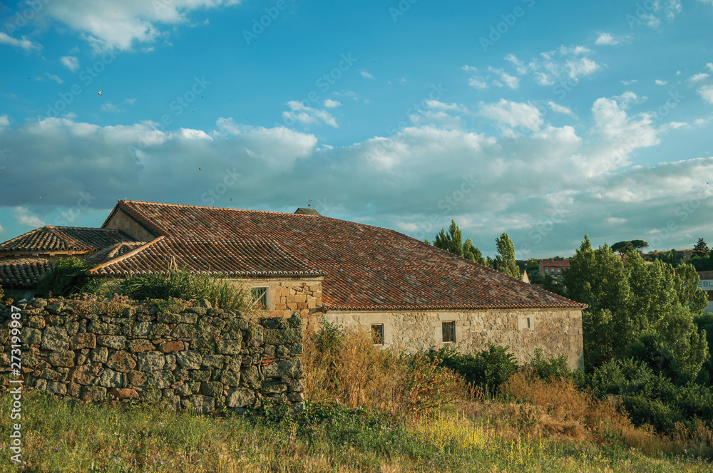 Stone wall and a worn house in hilly landscape at Avila