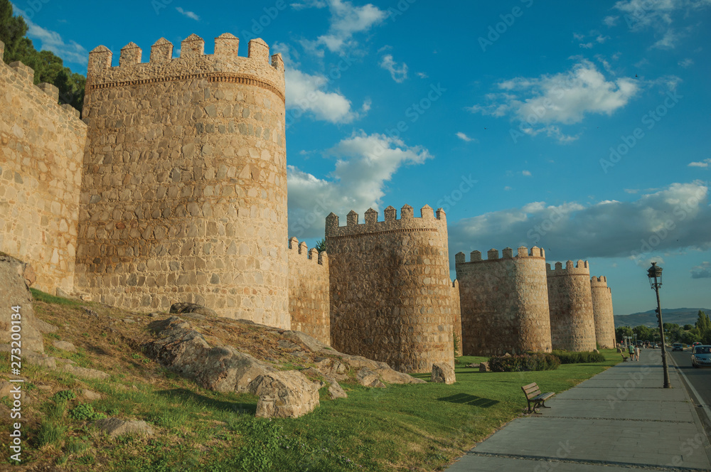 Sidewalk and stone towers on the large wall of Avila