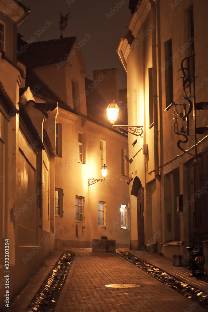 european empty old street, illuminated at night, in medieval town