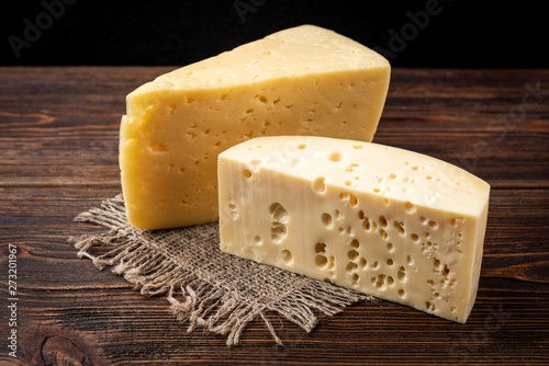 Cheese on dark wooden background.