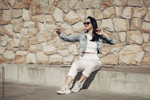 Beautiful Brunette Girl in Sunglasses White Pants and Jeans Jacket, Red Lipstick © Romvy
