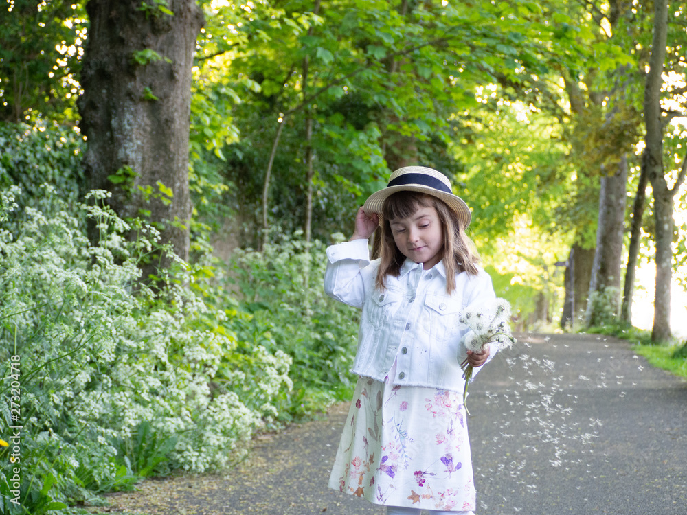 А pretty little girl is picking flowers. A sunny child in a straw hat is picking dandelions on a green glade. Summer girl. А pretty little girl is picking flowers. A sunny child in a straw hat is picking dandelions on a green glade. Summer girl.