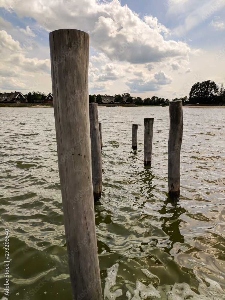 Holzpfosten stehen im Wasser 