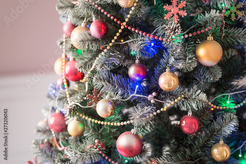 Christmas tree decorated with toys  balls and garland. Close up. Selective focus.