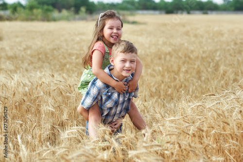 Children on a walk in a field of wheat . Funny brother and sister in the countryside © fisher05
