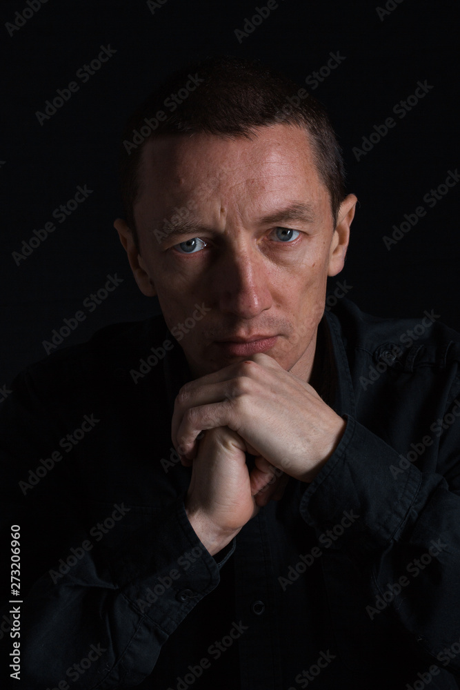 outdoor portrait of a very beautiful serious man, dark hair, posing in classic suit on black background