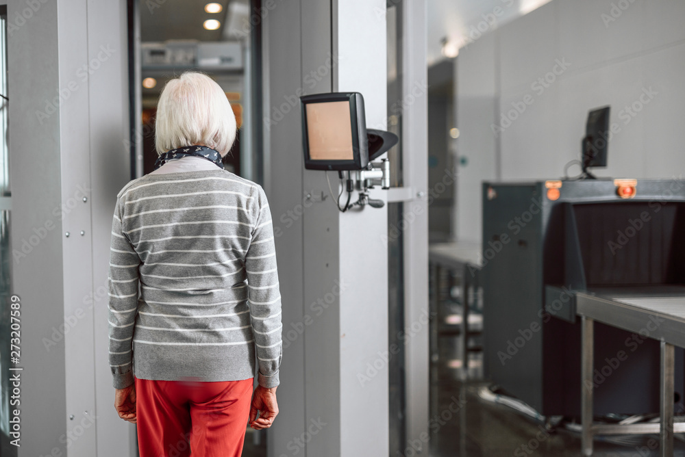 Old woman passing control at the airport through scanner Old woman passing control at the airport through scanner