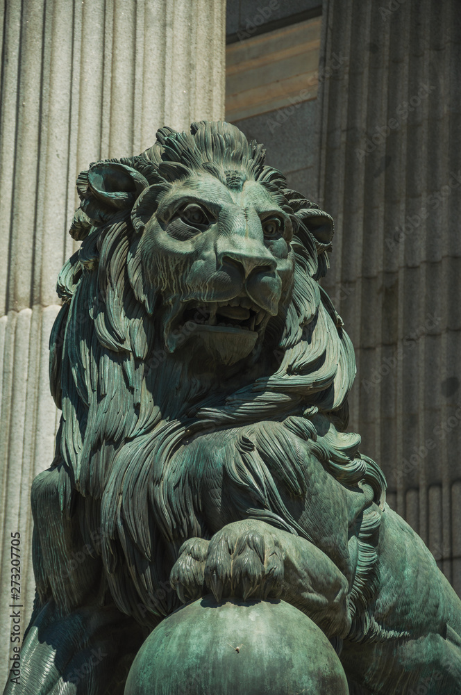 Sculpture lion cast in bronze on building facade in Madrid