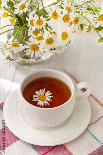 Still life with a cup of tea, cookies and daisies