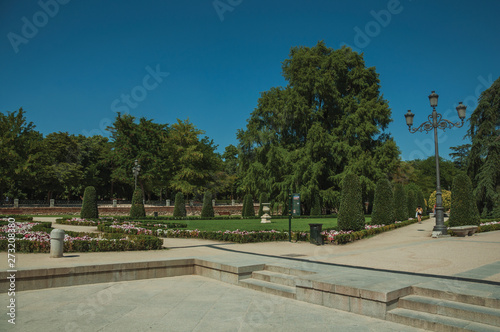 Pedestrian promenade with trees and streetlights in a park of Madrid