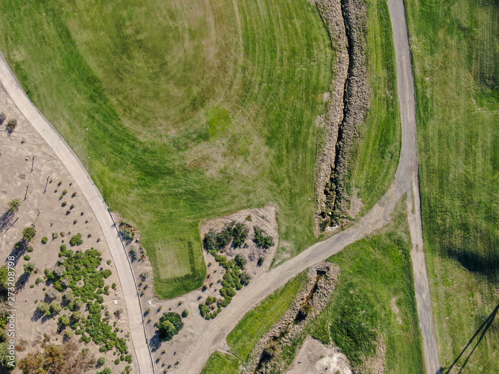 Fototapeta premium Aerial top view of a green golf course during sunny day. South California.