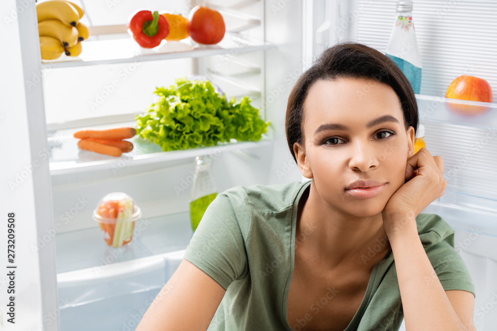 Close up of smiling lady with refrigerator back Close up of smiling lady with refrigerator back