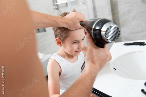 Father is doing hairstyle for his son