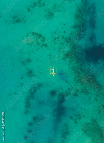 Aerial view of one boat in turquoise waters near Tagbilaran city, Philippines.