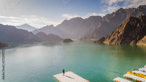 Aerial view of a woman standing in front of the Hatta Lake in Dubai, U.A.E. photo