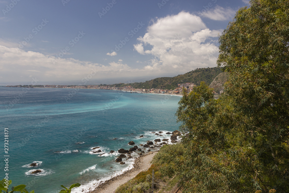 Giardini Naxos Sicily panorama of the coast and bay, beautiful sea with some rocks, trees and green hills
