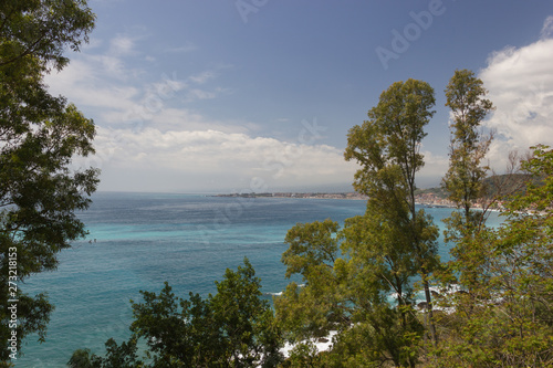 Giardini Naxos scenic panorama of the bay with green trees in front, blue seascape and sky © AlessioDCAuditore